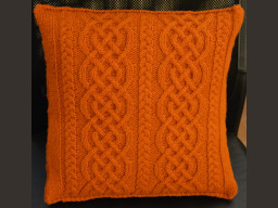 coussin tricoté avec un motif torsades